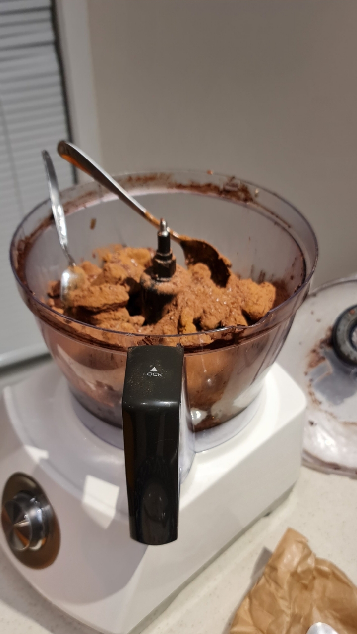 Food processor bowl full of the blended cocoa and nut base mixture