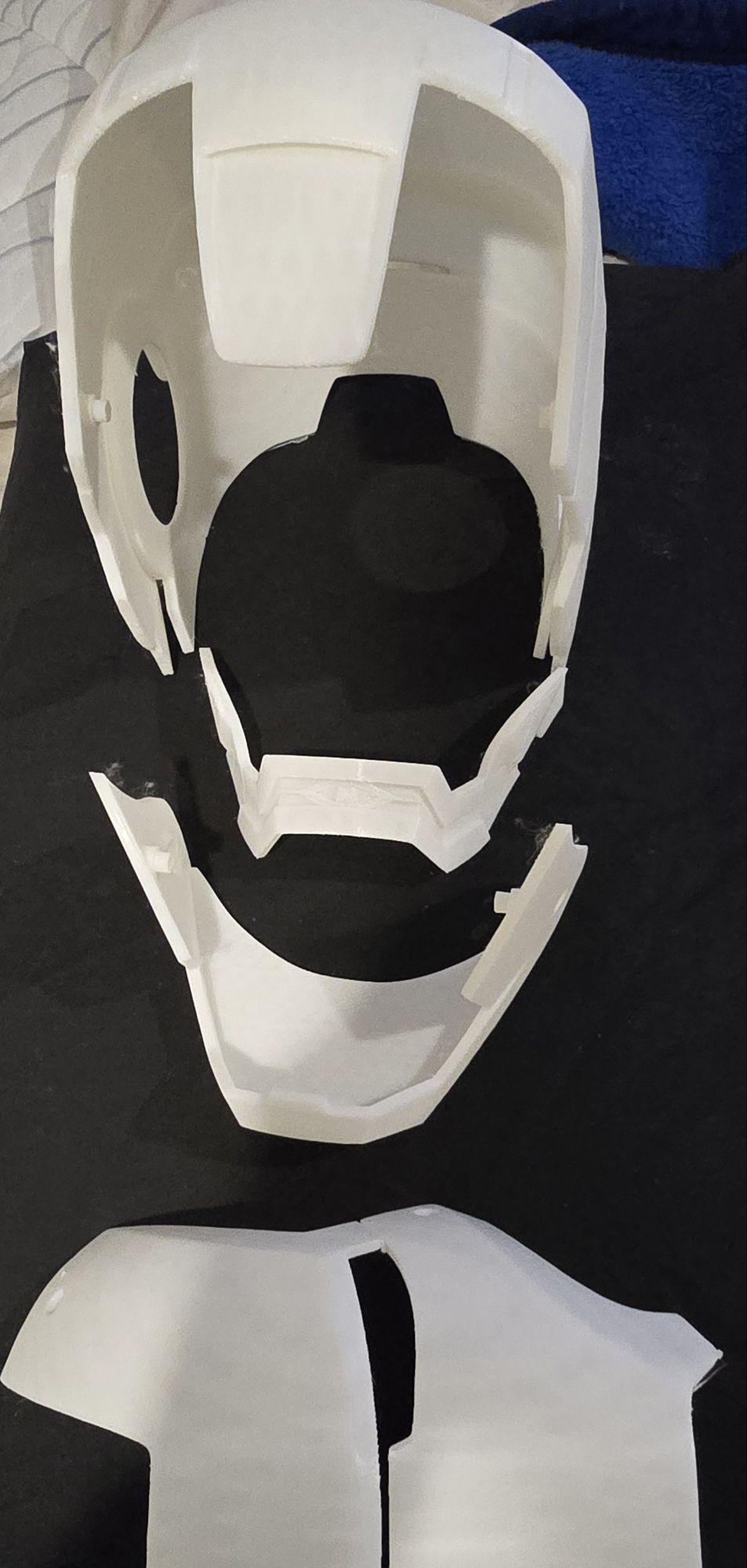 Printed helmet parts laid out unassembled: faceplate, jaw and chest piece
