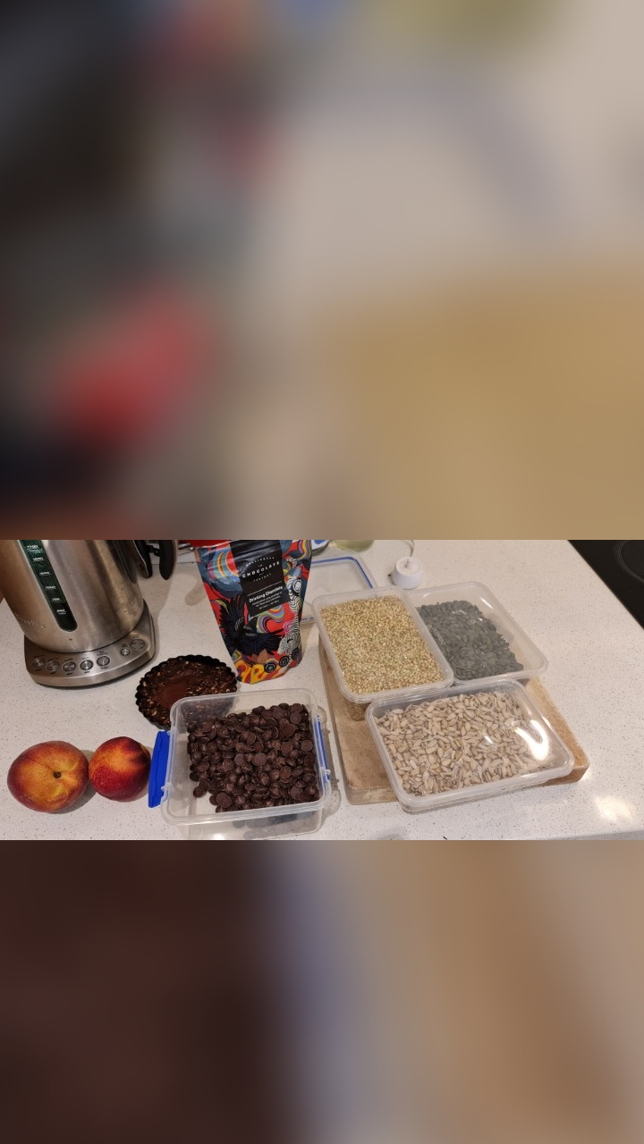 Ingredients laid out on the bench: chocolate drops, buckwheat, seeds and nectarines