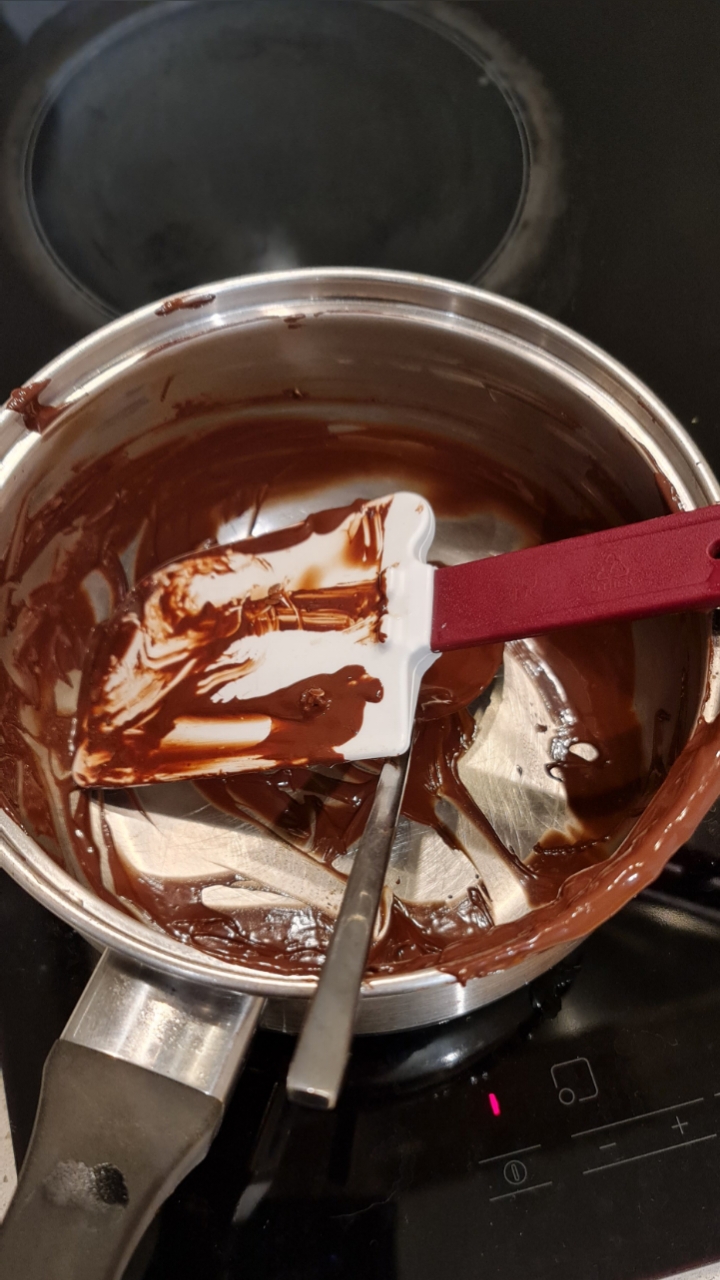 Chocolate melting in a saucepan with a spatula