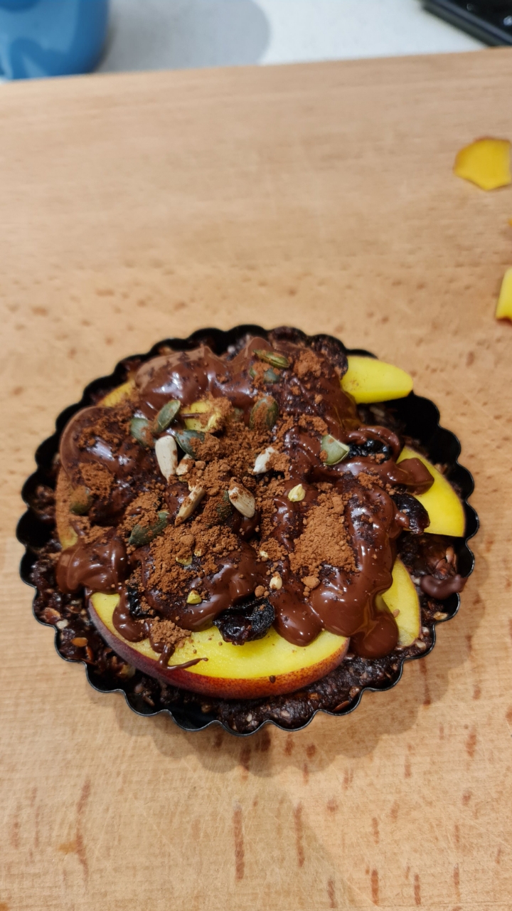 Close-up of the finished tart with chocolate drizzle, cocoa and pumpkin seeds
